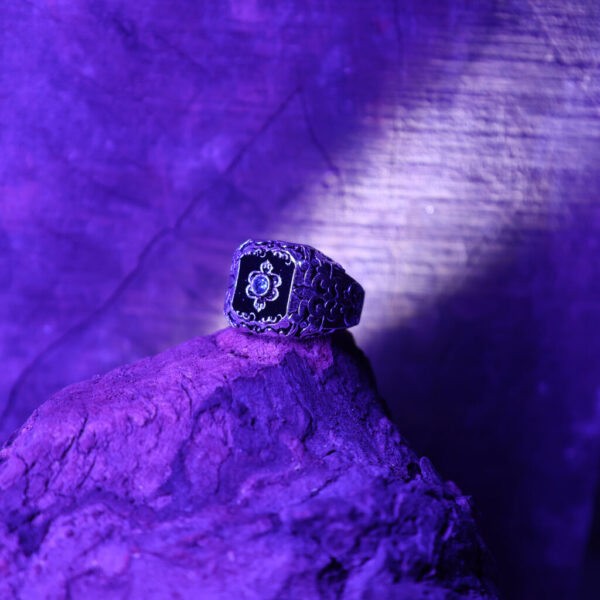 A blue Zenith ring placed on a wooden background with blue lighting.