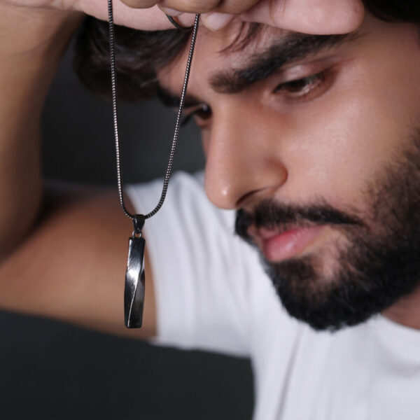 A twisted pendant with a black chain offers a bold and stylish look for men.