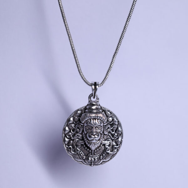 "Hanuman Ji pendant with a chain, hanging against a white background. The pendant features intricate details and is prominently displayed, with the white backdrop highlighting its design."