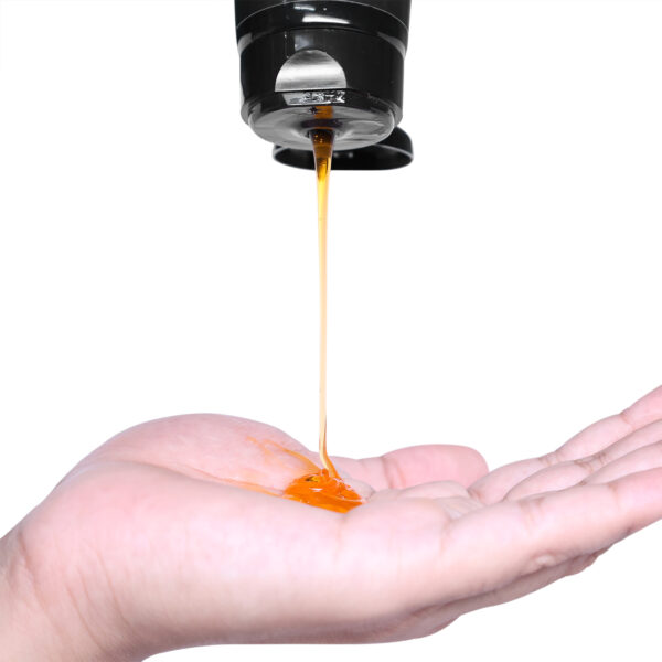 Face wash falling onto an open palm, set against a white background.