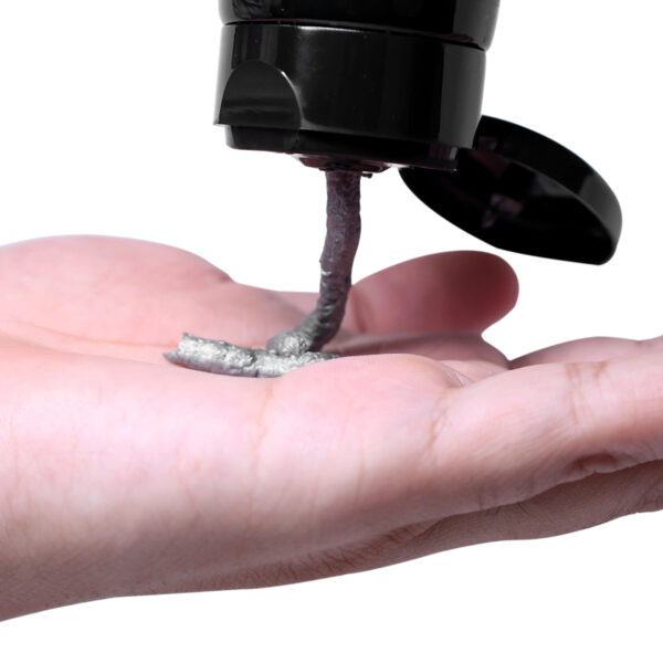 "A dark grey charcoal face wash being dispensed onto an open palm, set against a white background. The focus is on the rich, dark grey color of the face wash as it contrasts with the clean white backdrop and the skin tone of the hand."