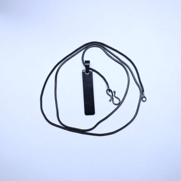 "Bar pendant with a black chain, displayed against a white background. The white backdrop highlights the sleek design of the pendant, making it stand out."