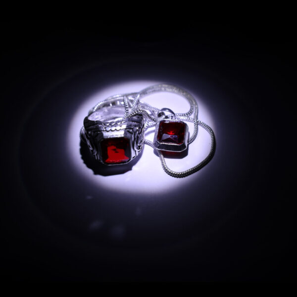 "Radiate elegance with our striking red gemstone ring and pendant, beautifully illuminated for a captivating allure."